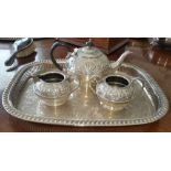 AN EMBOSSED THREE-PIECE SILVER-PLATED TEA SET on an engraved rope edge tray.