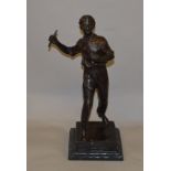 Bronze figure of a man carrying a baton (s/d to baton) mounted on a black marble square base.