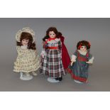 A group of three bisque head dolls, height of tallest 38 cm.