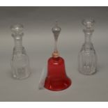 A 19th century Cranberry glass bell together with a pair of Victorian cut glass decanters with