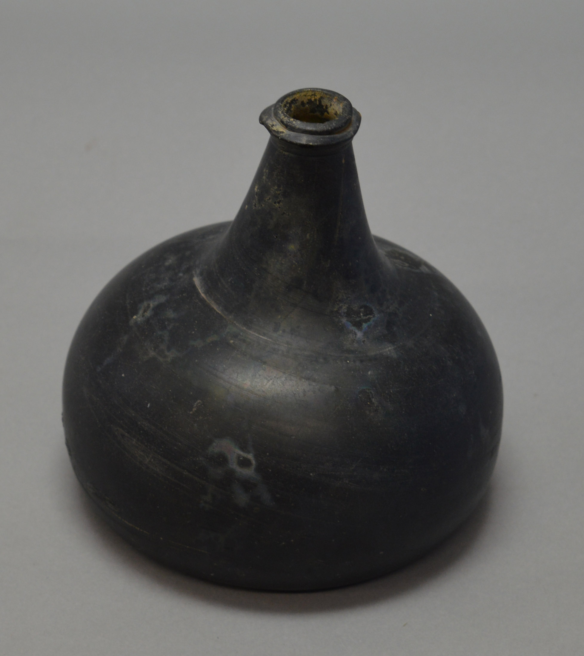 A 17th/18th century wine bottle, black glass with onion form.