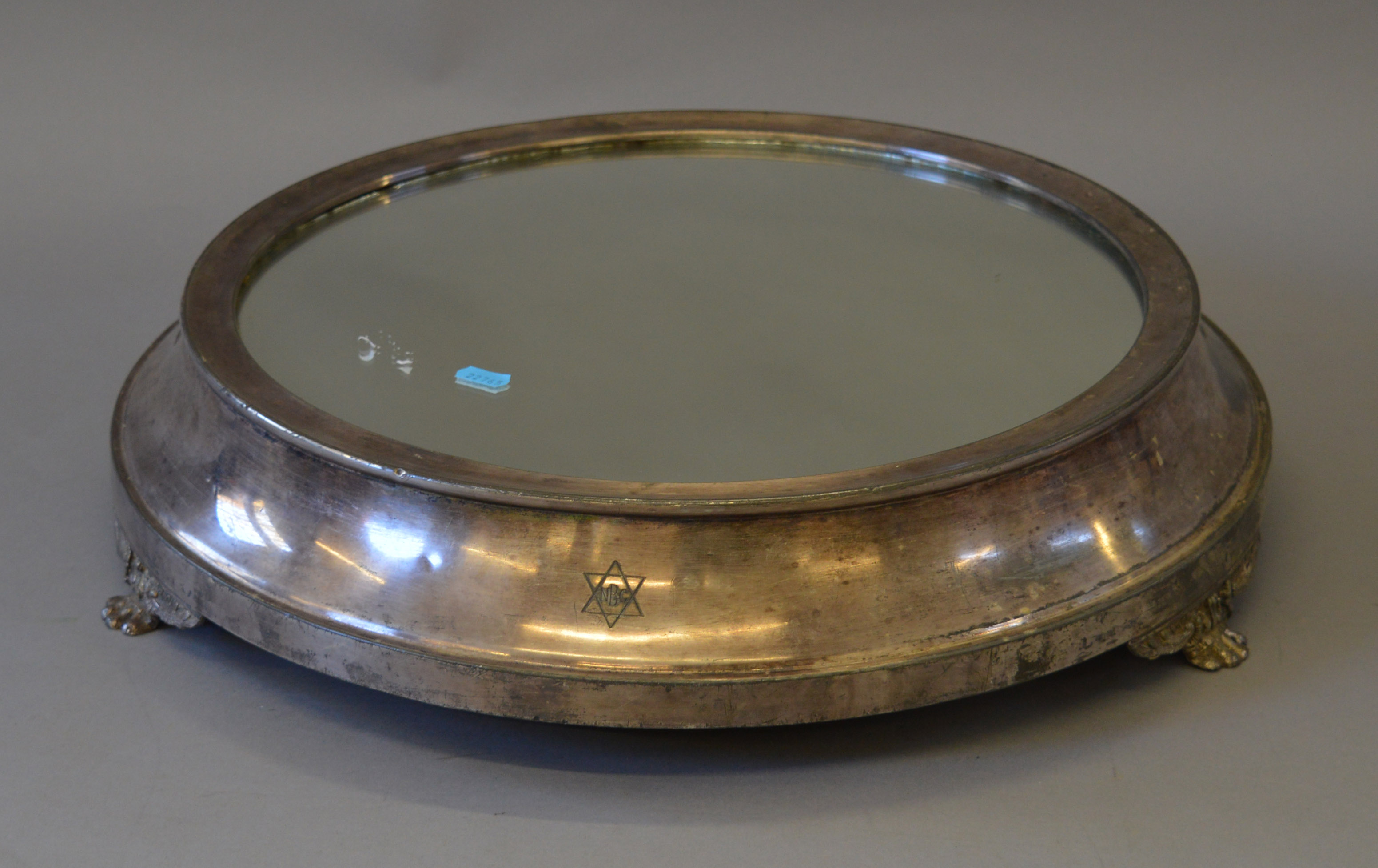 A large Walker and Hall mirrored cake stand of circular form with three pedestal feet.