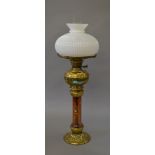 A large brass oil lamp with coloured glass stem. Height 80cm.