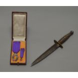 A Fairburn Sykes style dagger together with a French medal and minature, boxed.