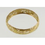 An Asian yellow metal bangle with engraved & pierced decoration, unmarked & approx 20.
