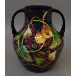 A large Moorcroft twin handled vase decorated with grapes, peaches and figs.