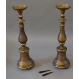 A pair of brass cast candlesticks, both marked "AM 2007" and No. 0299 and No. 373 respectively.