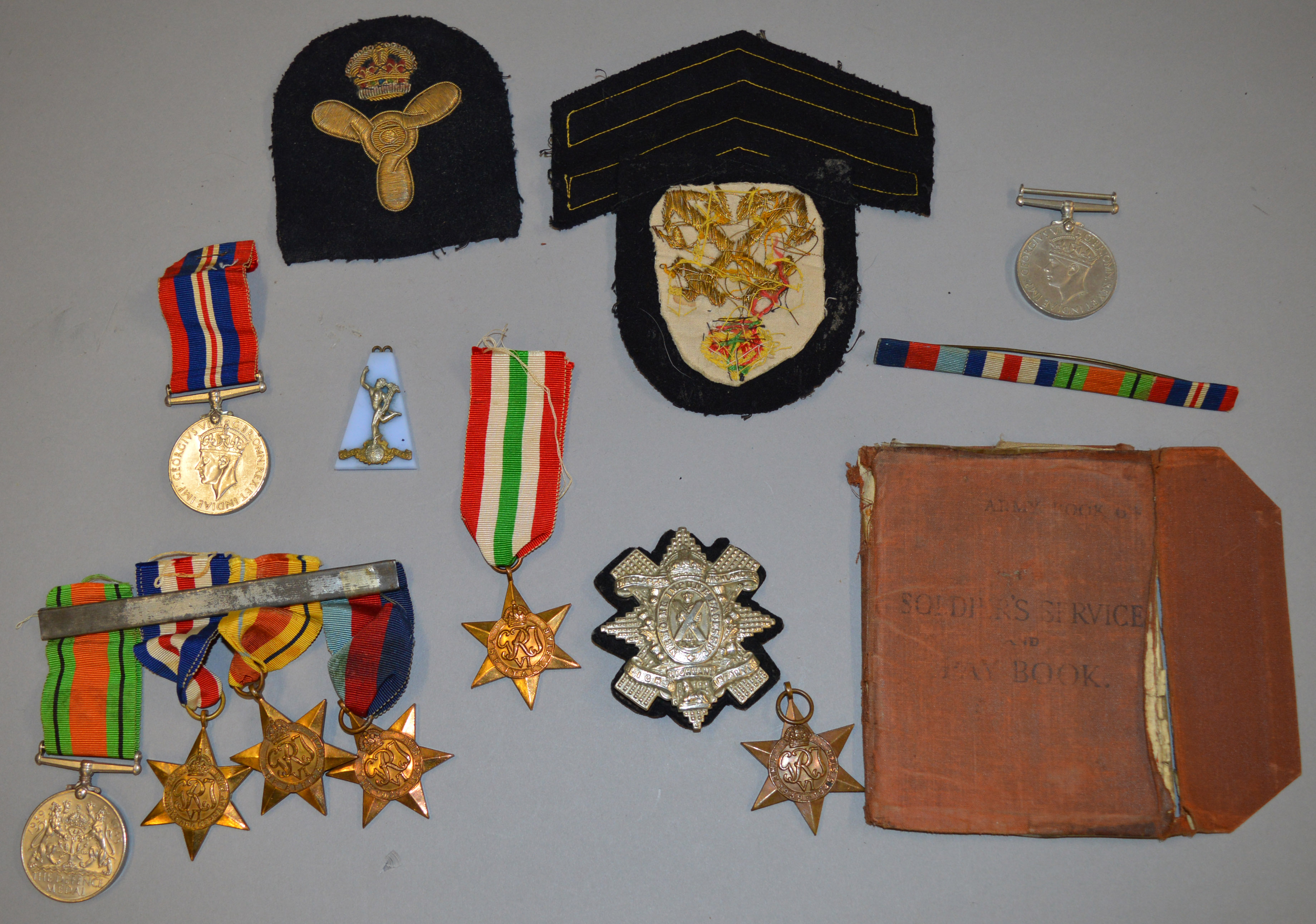 Collection of various medals and similar including a WW2 Army pay book, cap badges, ribbon bars etc.
