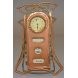 An Art Nouveau copper cased mantle clock and calendar. 25cm x 17cm.