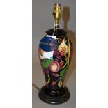 A Moorcroft lamp base decorated with grapes, peaches and figs. 38cm tall.