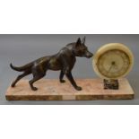 An Art Deco marble mantle clock with spelter hollowcast dog adornment set on marble base. 72cm long.