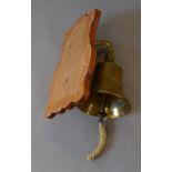 A ships bell marked "1888", mounted on pine board.