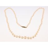A string of graduated cultured pearls individually knotted with a yellow metal barrel clasp,