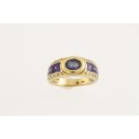 A modern FABERGE 18ct ring (stamped 750) set with a central oval sapphire,