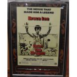 An Enter The Dragon Bruce Lee poster framed and glazed with a replica of the nunchaku seen in the