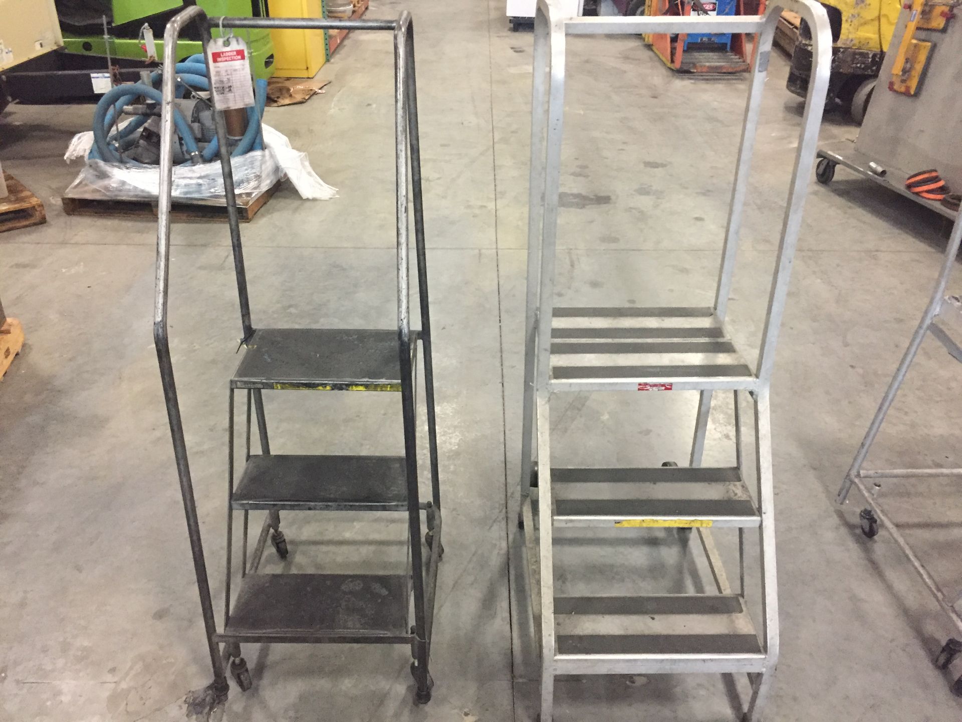 TWO ROLLING STAIR CASES (ONE STEEL, ONE ALUMINUM)