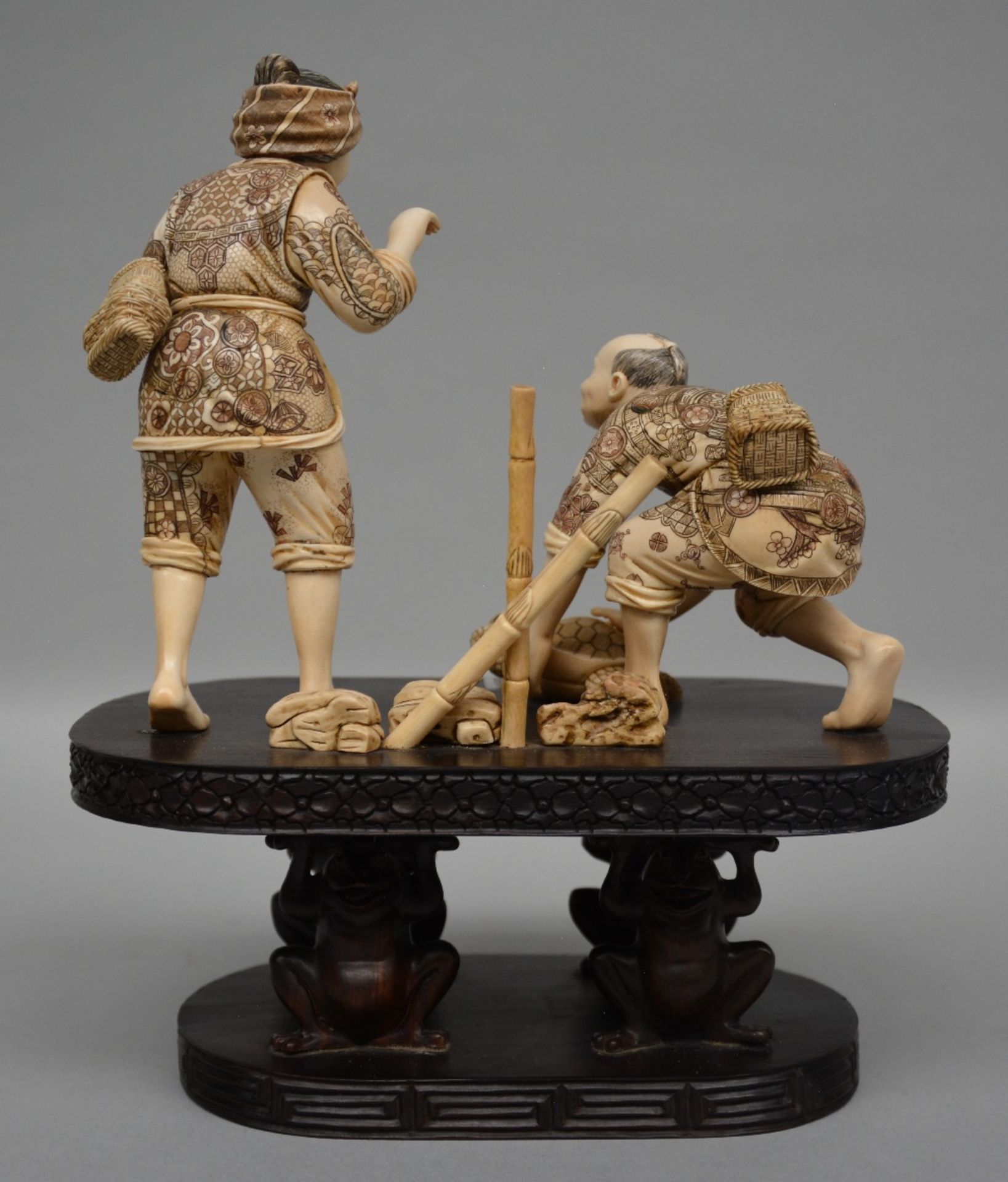 A charming Japanese ivory okimono of two figures playing with a tortoise, red and black scrimshaw - Bild 3 aus 6