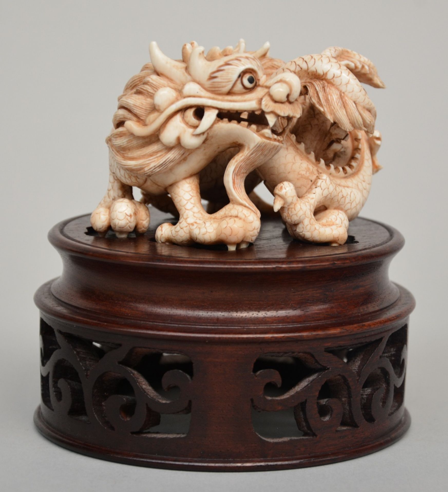 An Oriental ivory group of playing dragons on a wooden base, scrimshaw decorated, H 6 cm (without