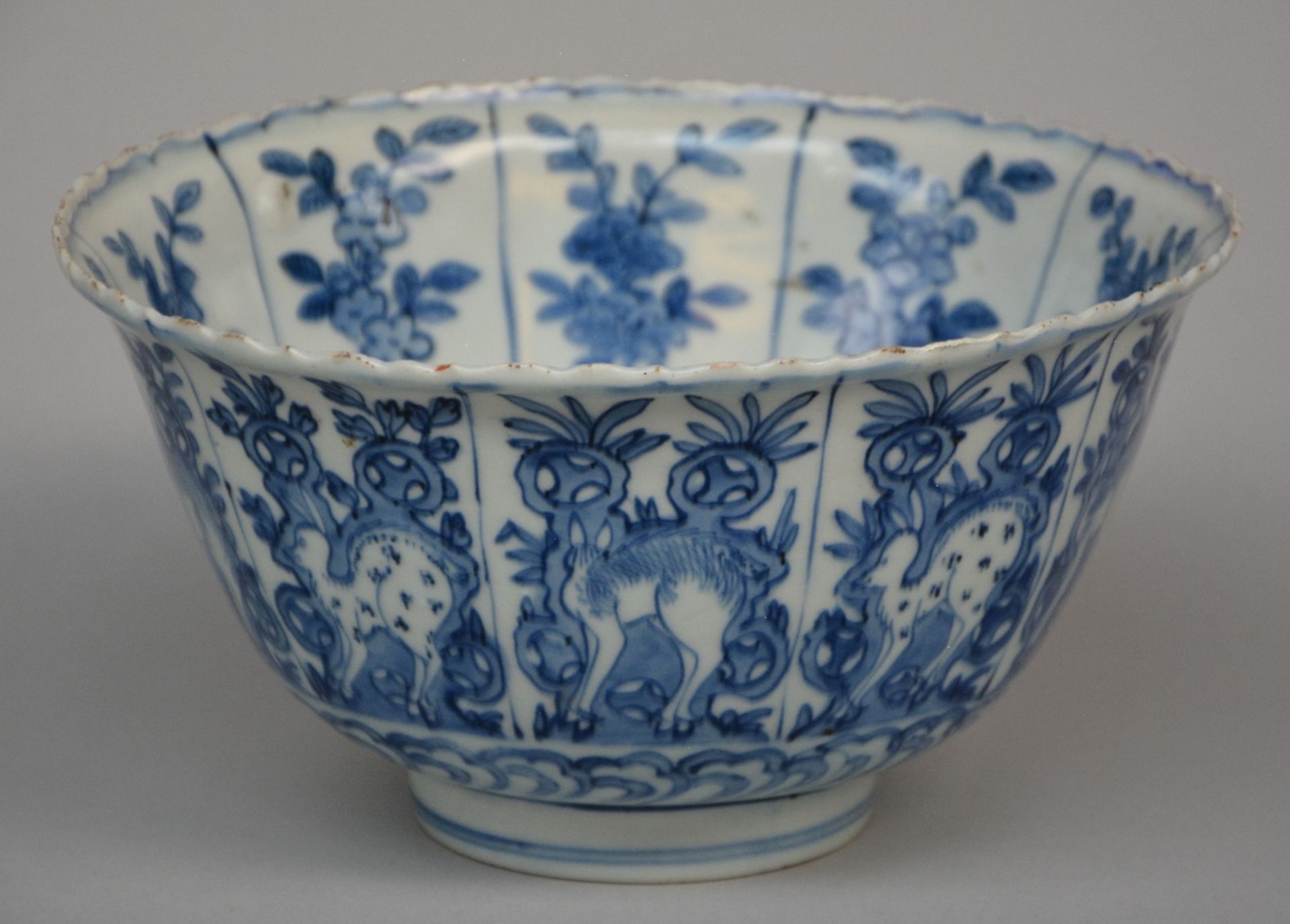 A Chinese blue and white bowl with fluted rim, overall decorated with deer in a landscape, on the