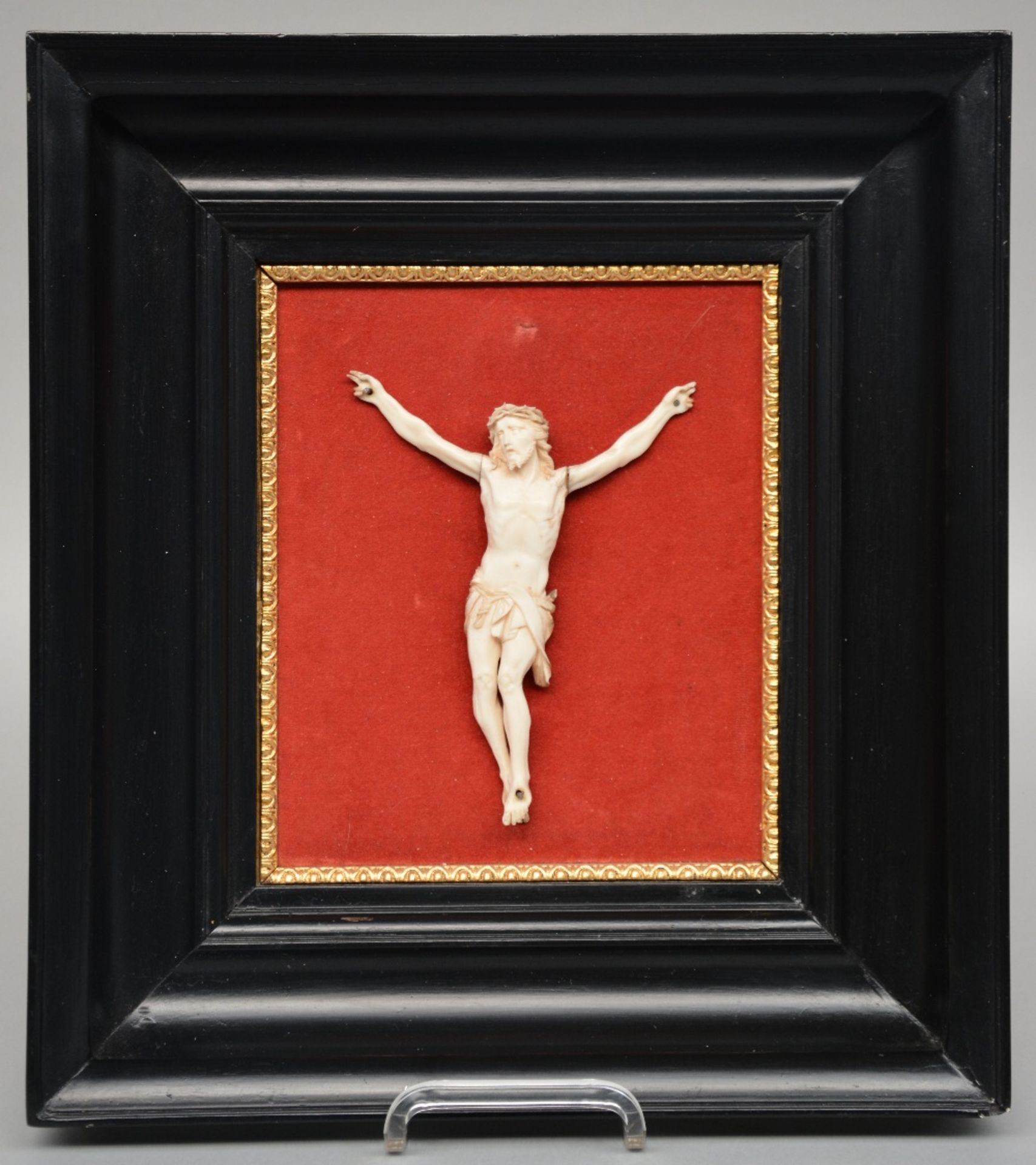 An ivory Christ, 19thC, in an ebonised frame, 14 x 18 cm (Christ), 36 x 40 cm (frame) (some damage)
