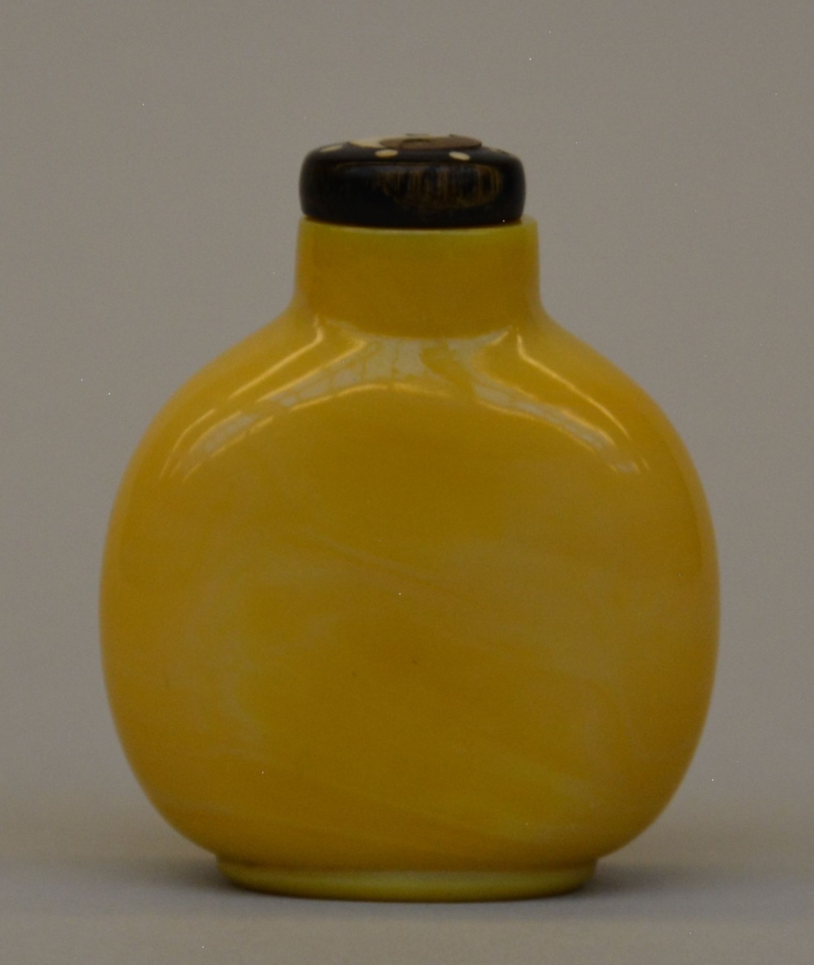 A fine Imperial yellow glass snuff bottle, perferctly modelled ovoid shape, standing on an oval