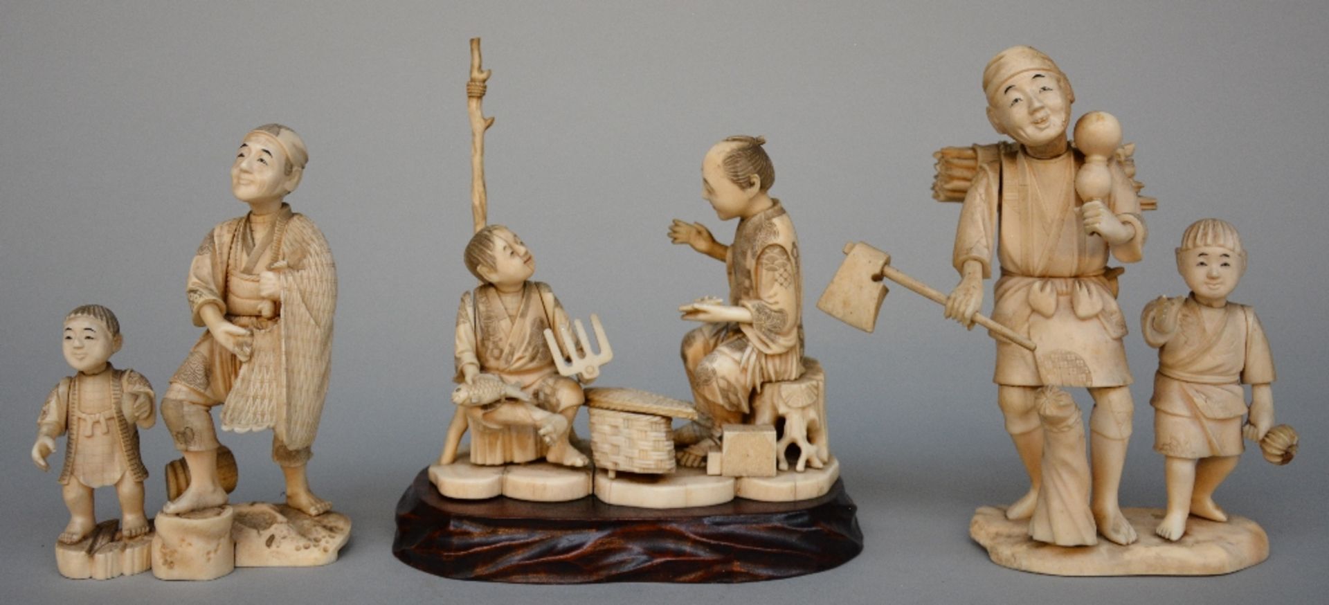 Three Japanese ivory okimino figures of father and son, scrimshaw decorated, Meiji period, H 19