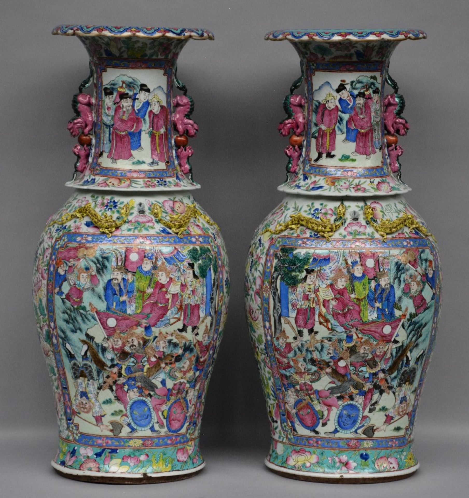 A pair of Chinese impressive famille rose vases, decorated with warriors and a court scene, one vase