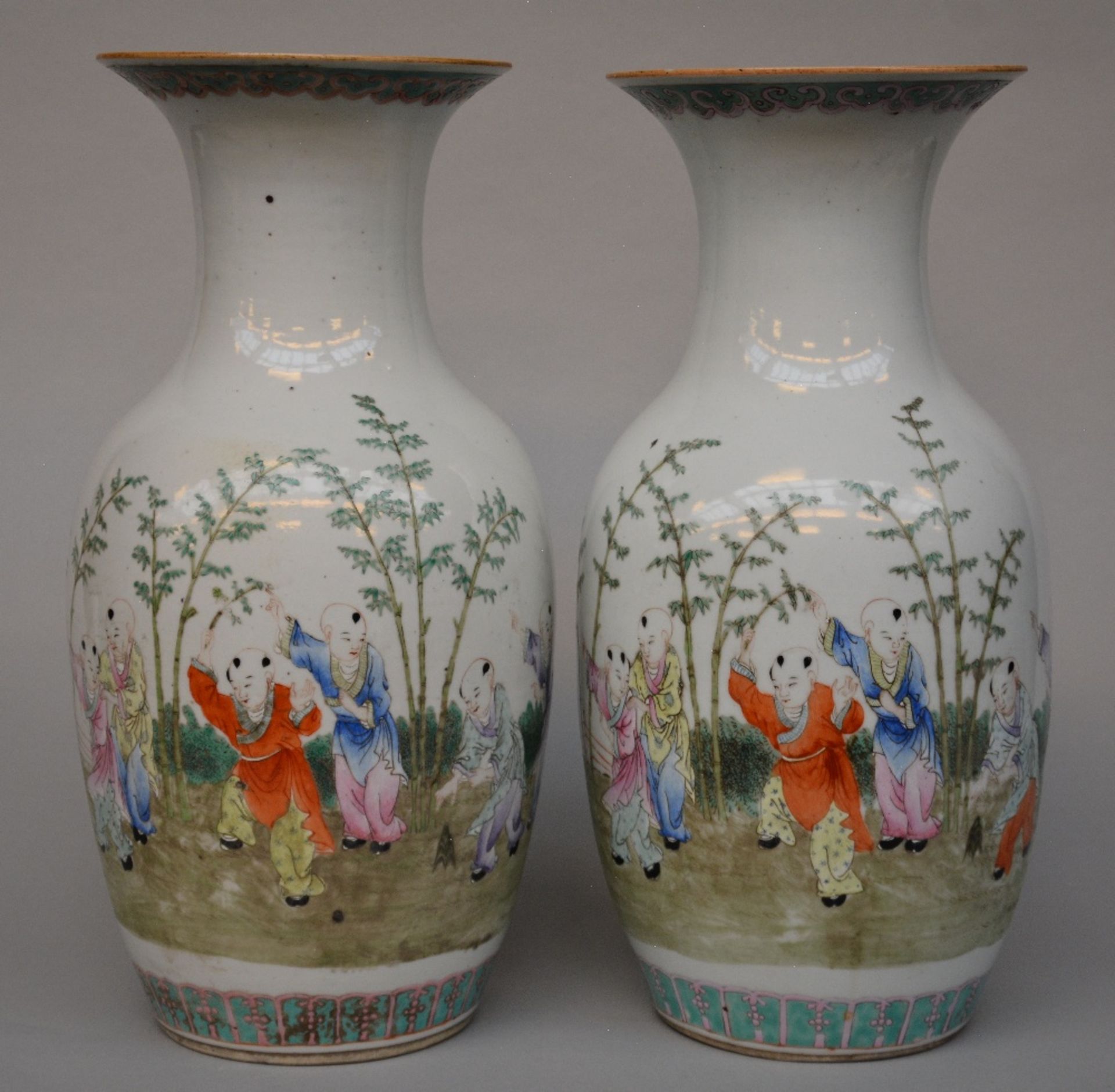 A pair of Chinese polychrome decorated vases depicting children playing in a garden, marked,