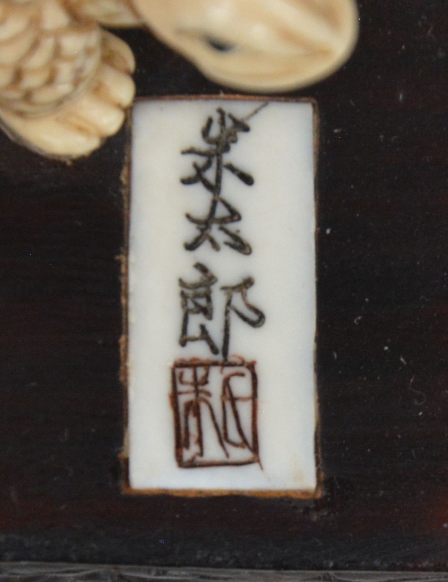 A charming Japanese ivory okimono of two figures playing with a tortoise, red and black scrimshaw - Image 6 of 6