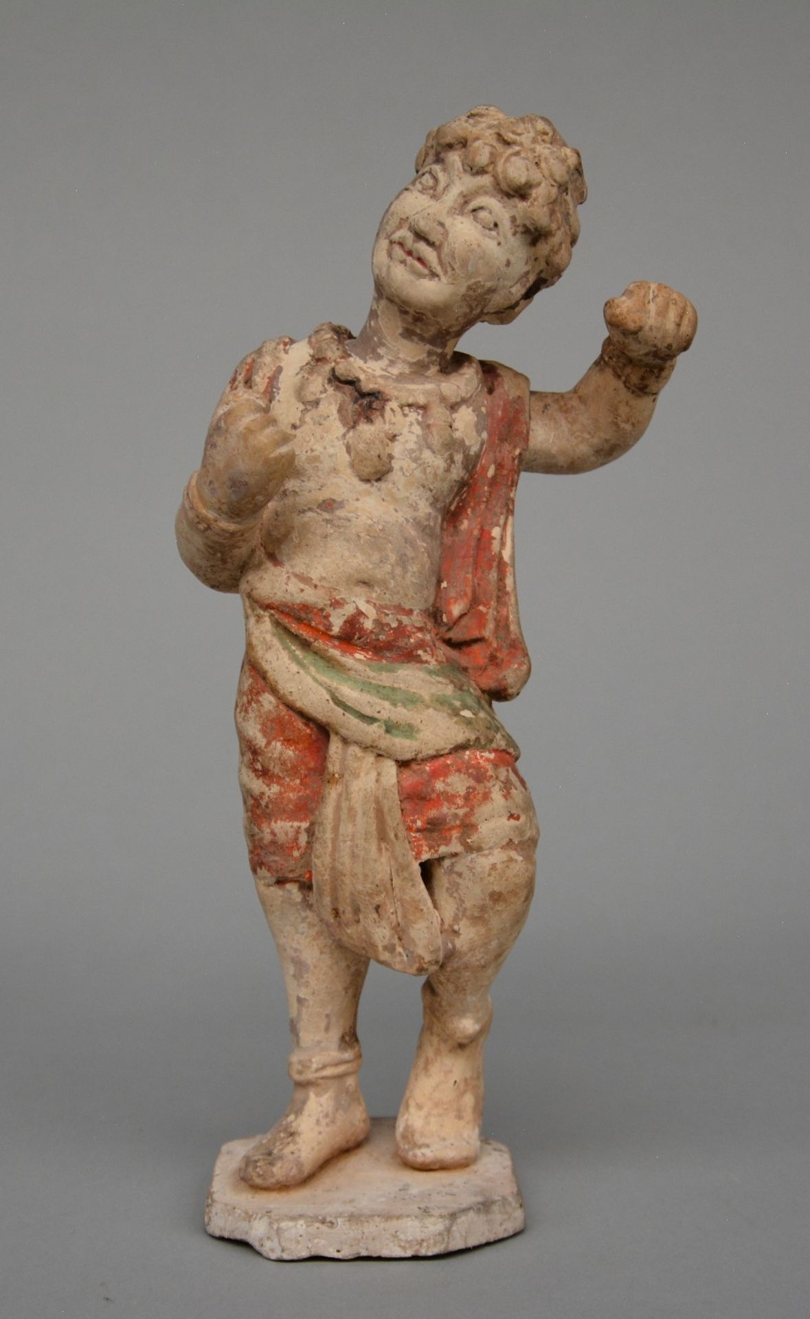 A Chinese polychrome terracotta figure of a foreign boy, Tang dynasty (618-906), H 27 cm (with TL