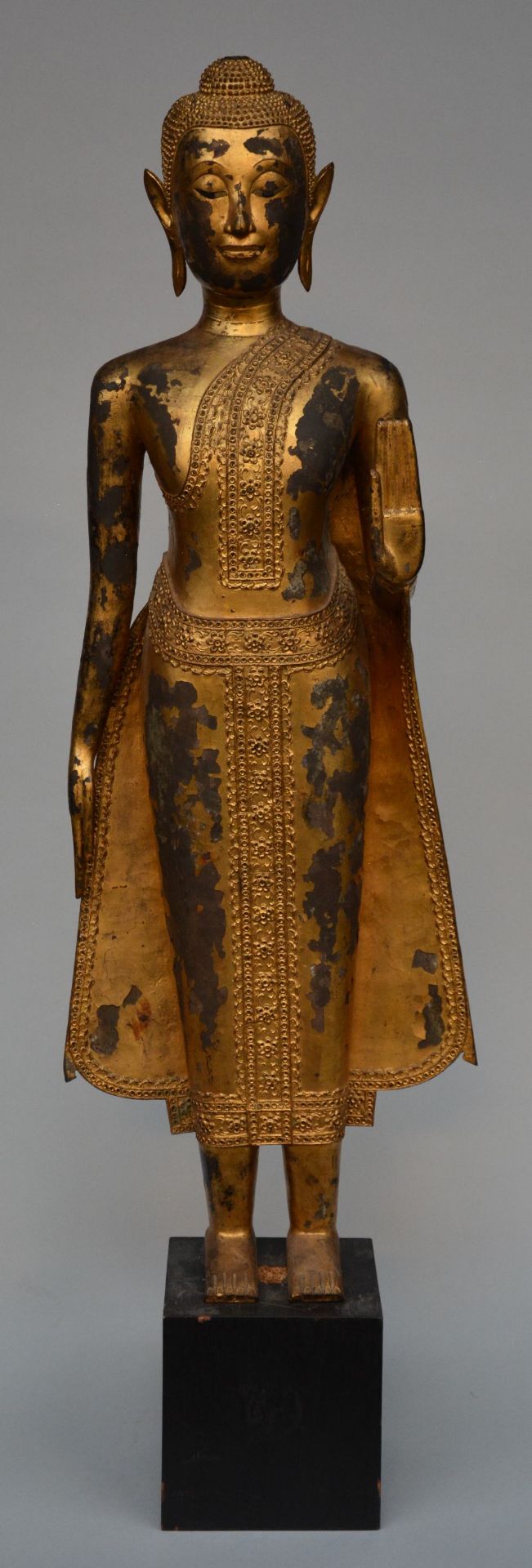 An Oriental gilt standing Buddha on a wooden base, H 126 cm