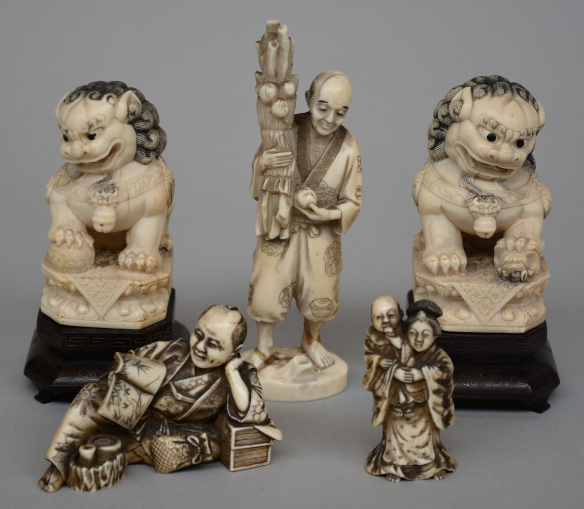 A pair of Chinese ivory Fu lions, on a wooden base, scrimshaw decorated, early 20thC, H 12,3 cm;