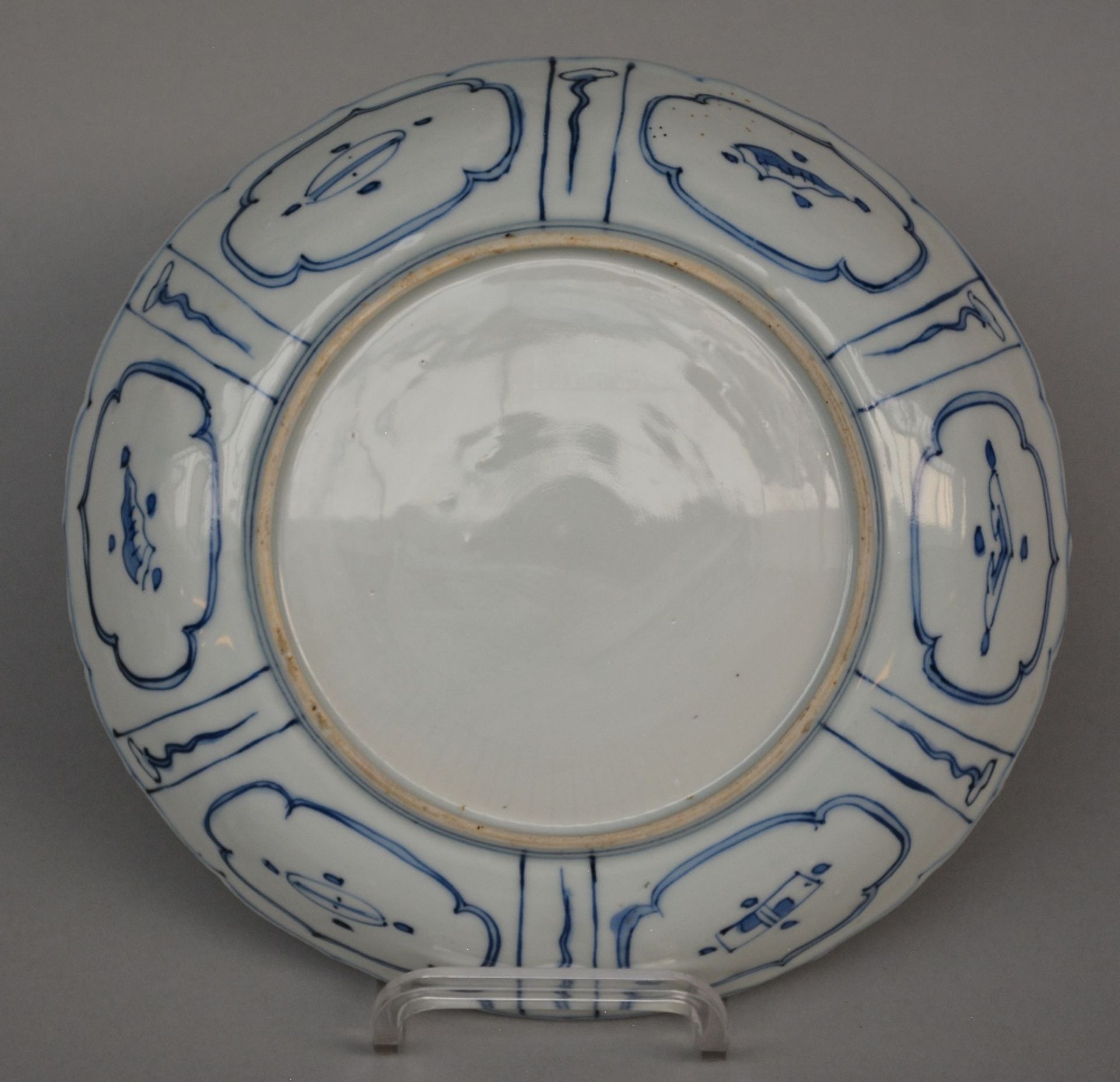 A Chinese blue and white plate with fluted rim and relief decoration, painted with a lady in a - Bild 2 aus 2