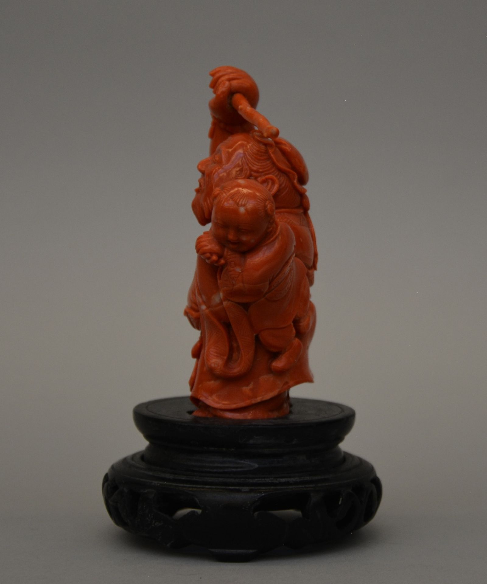 A Chinese carved red coral sculpture of an old man with a child, H 16,5 cm, Weight 565 g (minor - Bild 2 aus 6