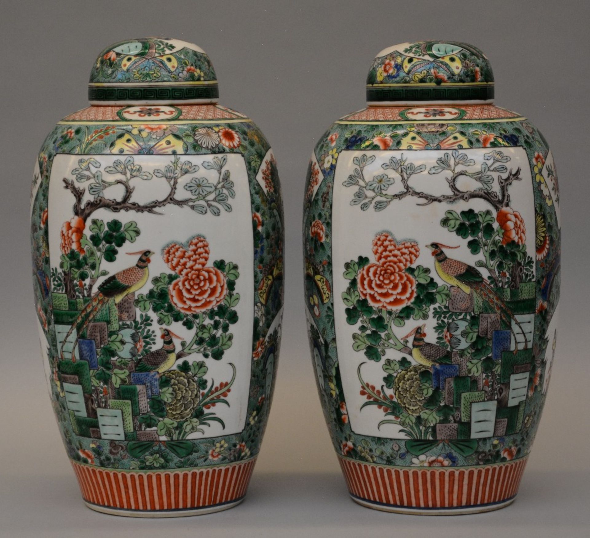 A pair of Chinese famille verte pots with cover, painted with floral motifs, birds and a