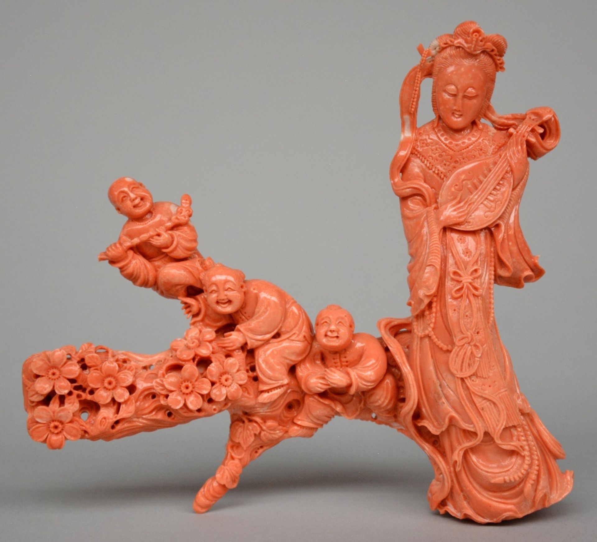 A Chinese red coral sculpture depicting a lady playing music and three children, H 18 - W 20 cm,