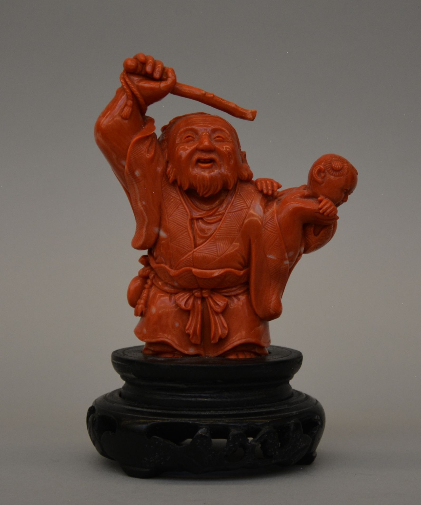 A Chinese carved red coral sculpture of an old man with a child, H 16,5 cm, Weight 565 g (minor