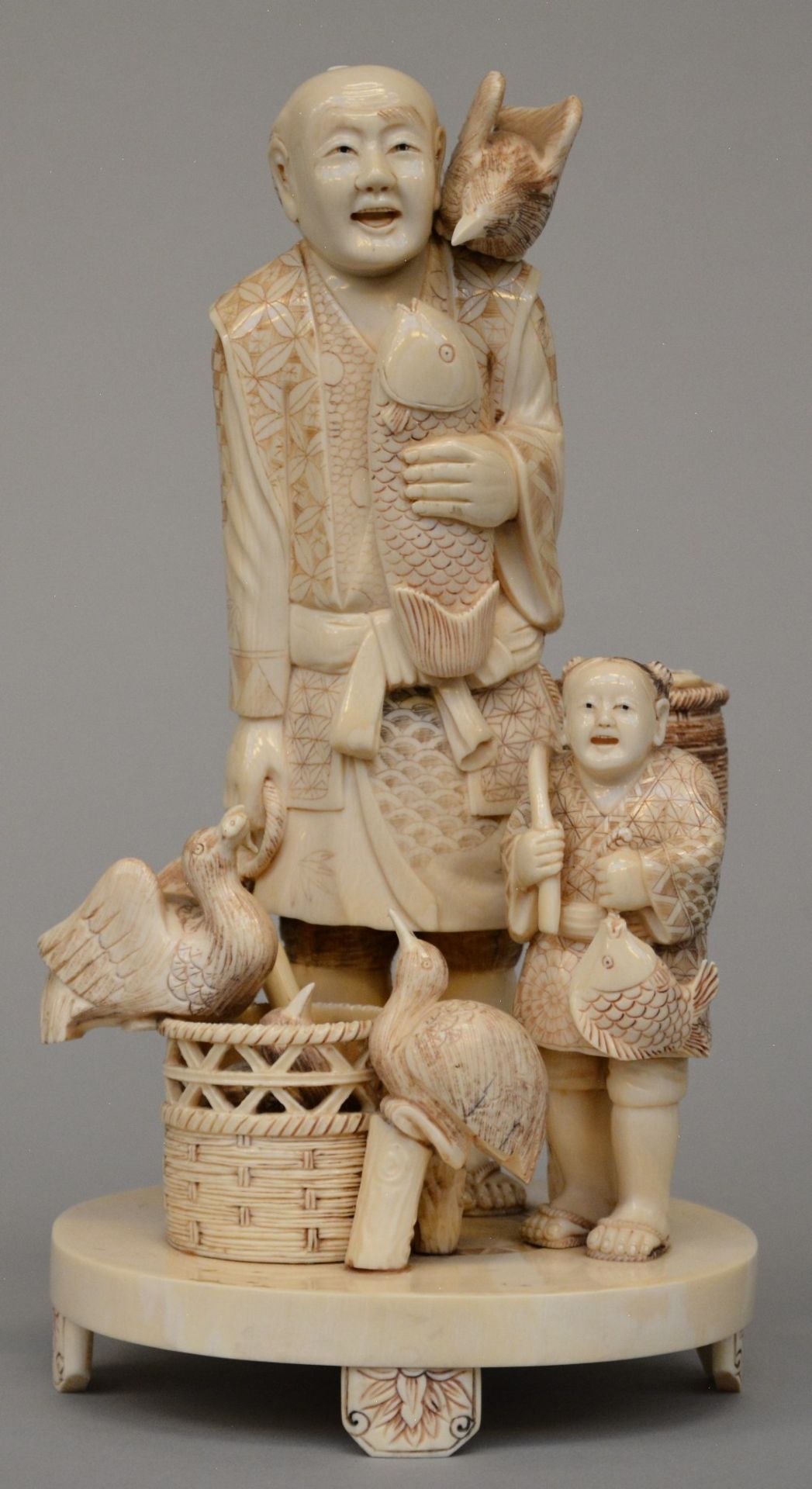 A Japanese ivory okimono of street vendors, Meiji period, H 26,5 cm - Weight 1.272 g