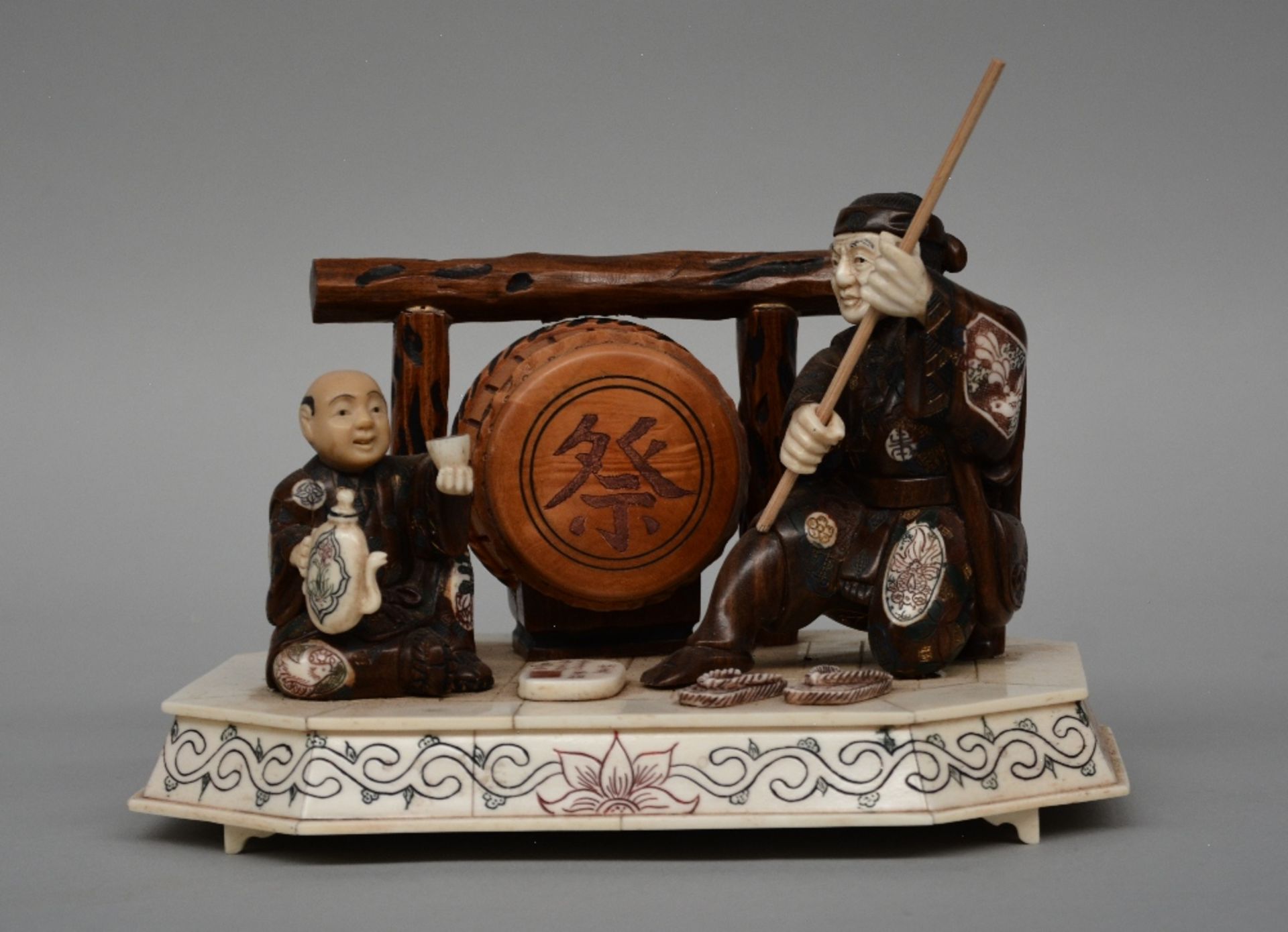 A Japanese okimono in exotic hard wood and bone, scrimshaw decorated, late Meiji period, H 16,5 cm