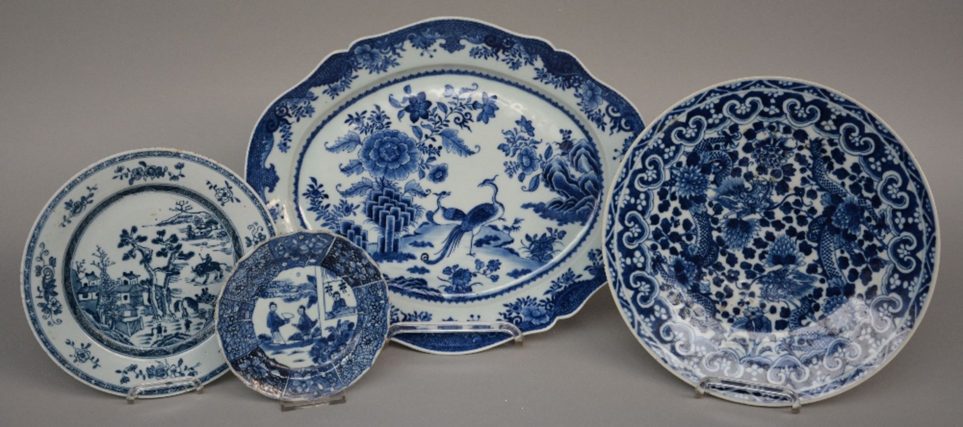 Four Chinese blue and white decorated plates depicting birds, flowers, dragons and figures, 18thC/