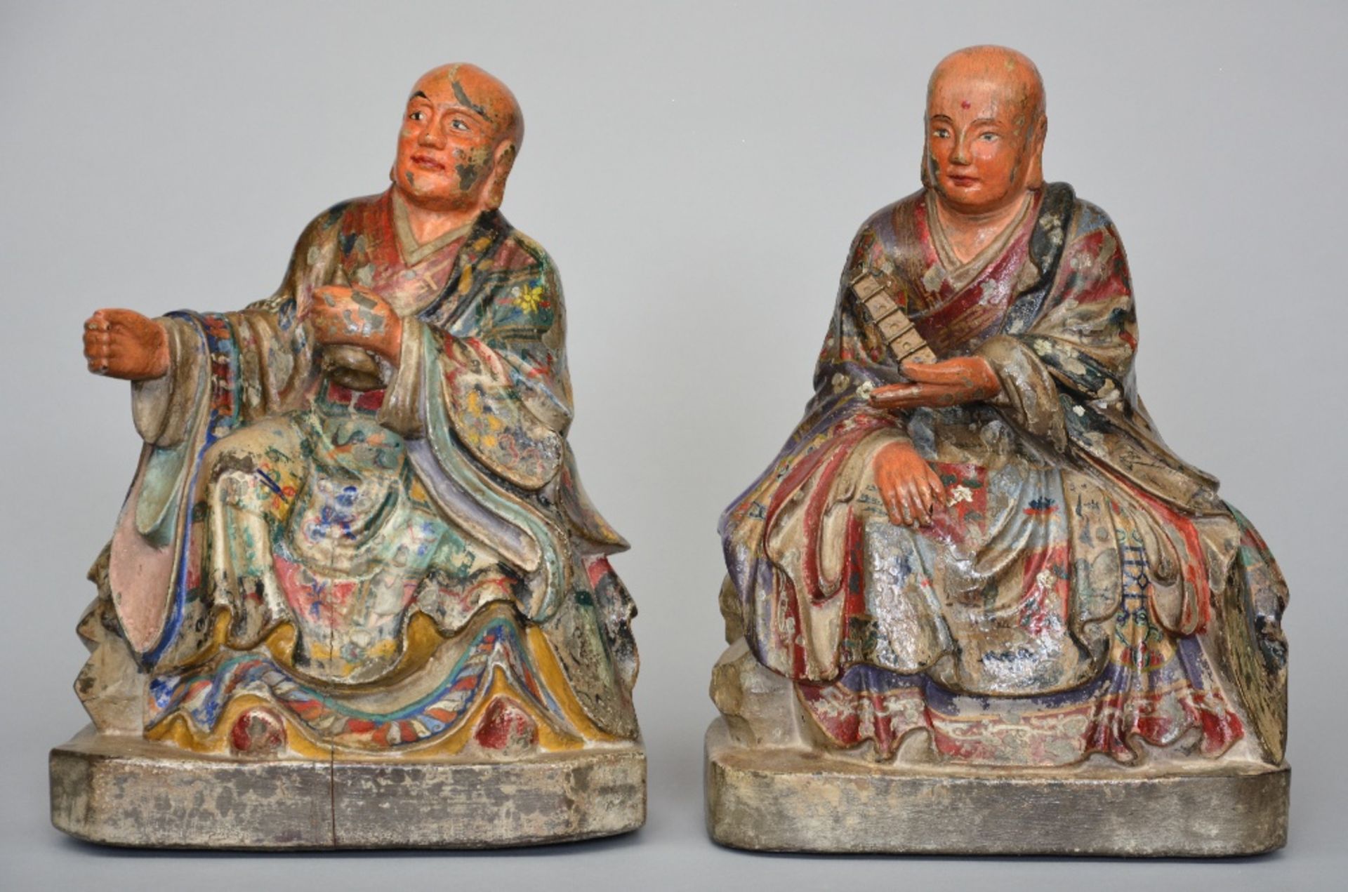 Two Oriental polychromed wooden Buddhist monks, ca. 1900, H 31 - 32 cm (damage to the polychrome)