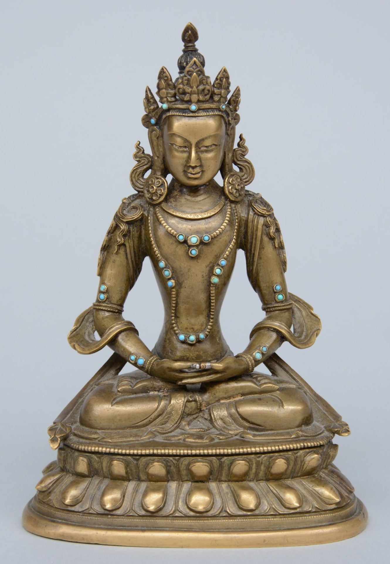 A Tibetan bronze seated Buddha with inlay turqouise, semi-precious stones, 18thC, H 17,5 cm