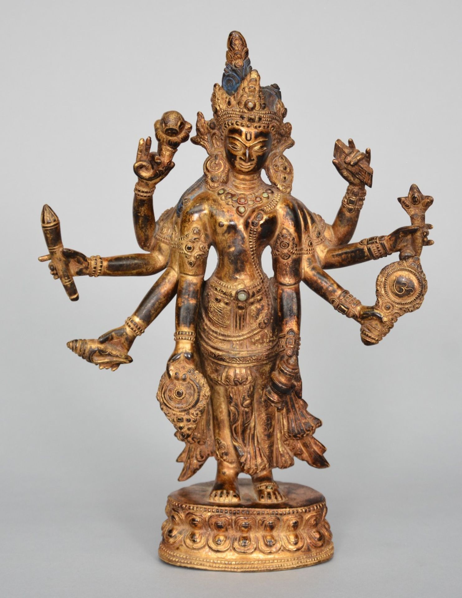 An Oriental gilt bronze polychrome figure, representing Shiva, decorated and inlaid with various