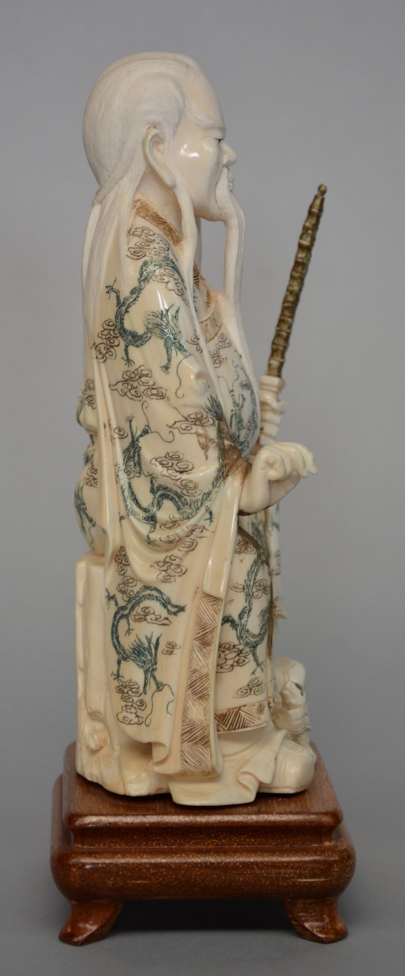 A Chinese ivory sculpture of a deity, on wooden base, scrimshaw decorated, first half 20thC, H 25 cm - Image 4 of 4