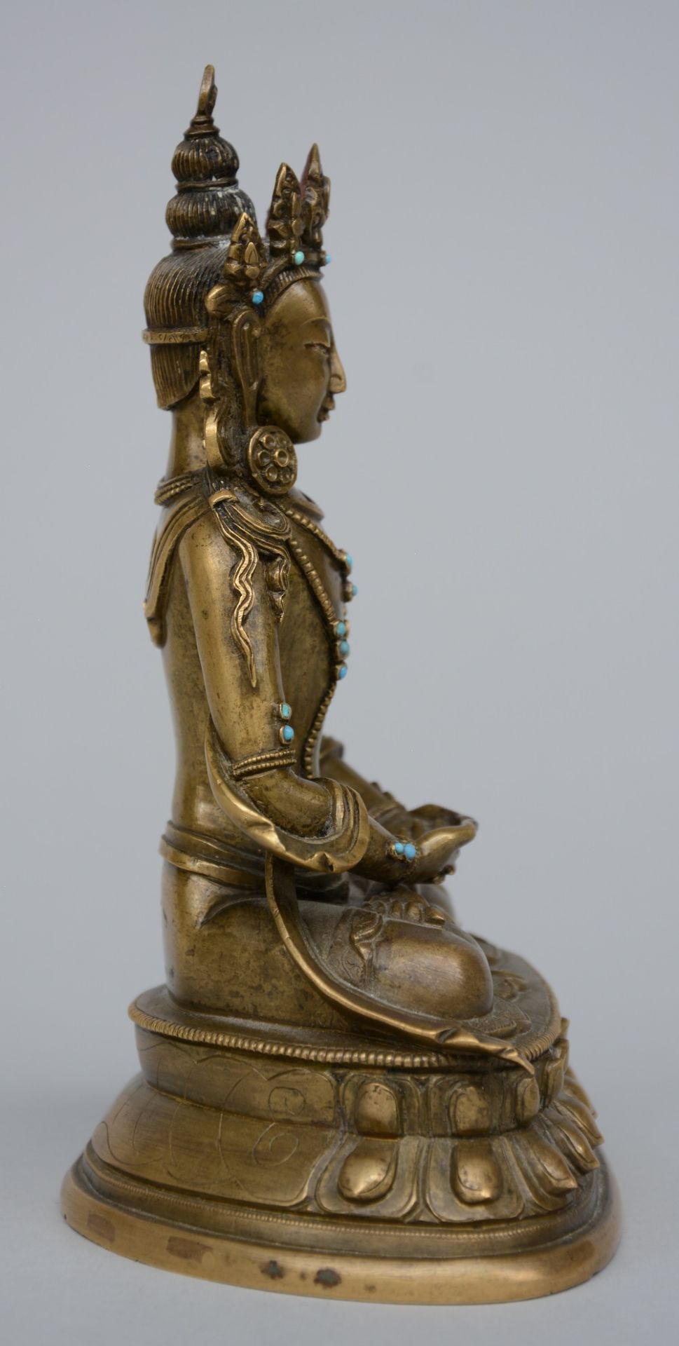 A Tibetan bronze seated Buddha with inlay turqouise, semi-precious stones, 18thC, H 17,5 cm - Image 5 of 7