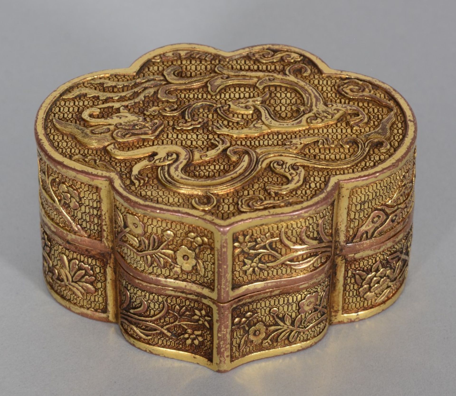 A Chinese gilt bronze box with cover, relief decorated with a dragon, a phoenix and flowers,