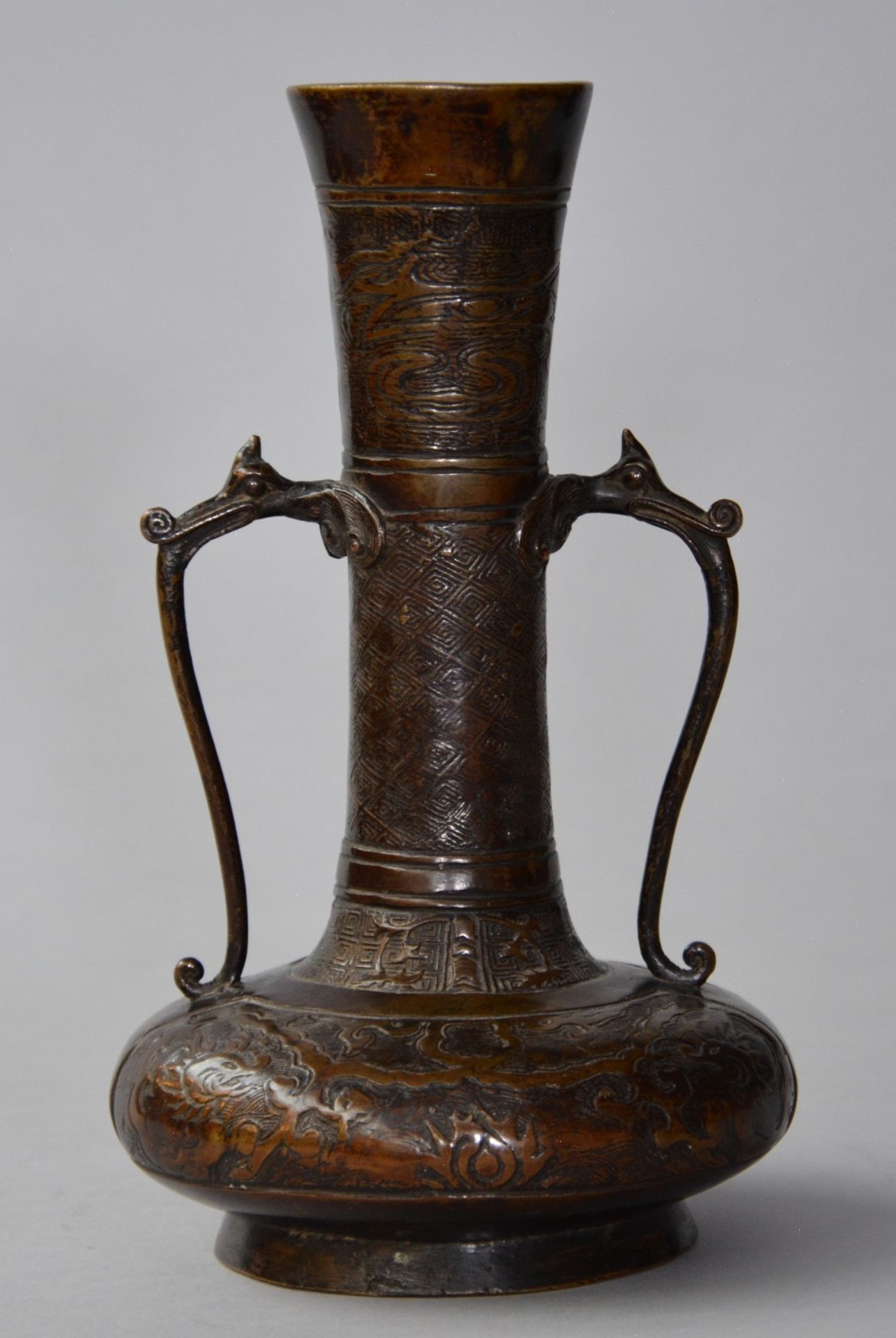 An archaic Chinese bronze vase with relief decoration of dragons, H 23,5 cm