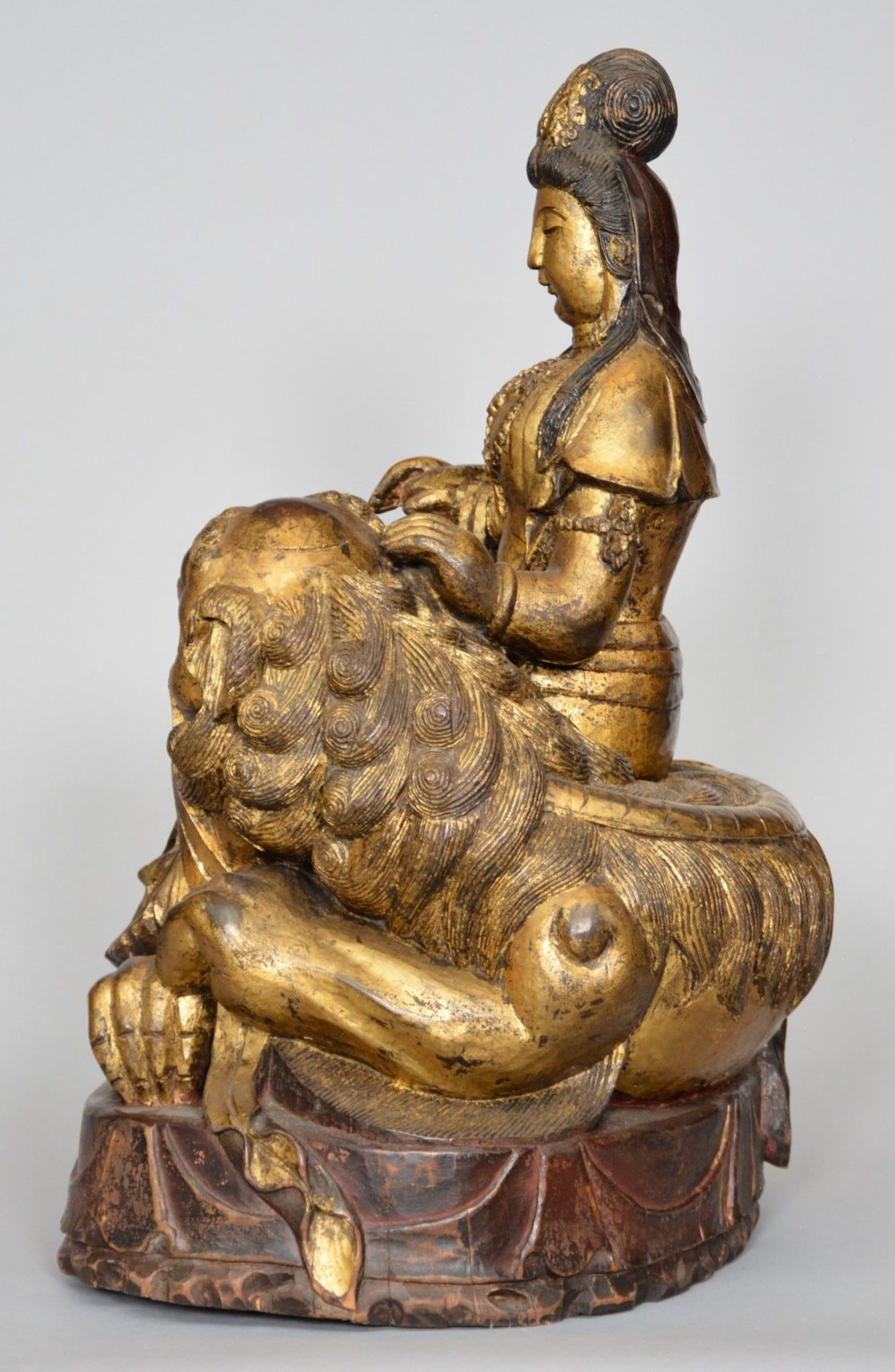 A Chinese polychromed and gilt wooden sculpture figuring a Guanyin sitting on a Fu lion, ca. 1900, H - Image 2 of 6