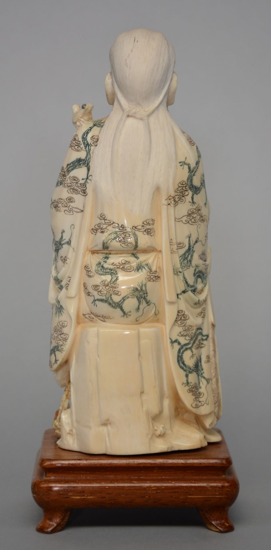 A Chinese ivory sculpture of a deity, on wooden base, scrimshaw decorated, first half 20thC, H 25 cm - Image 3 of 4