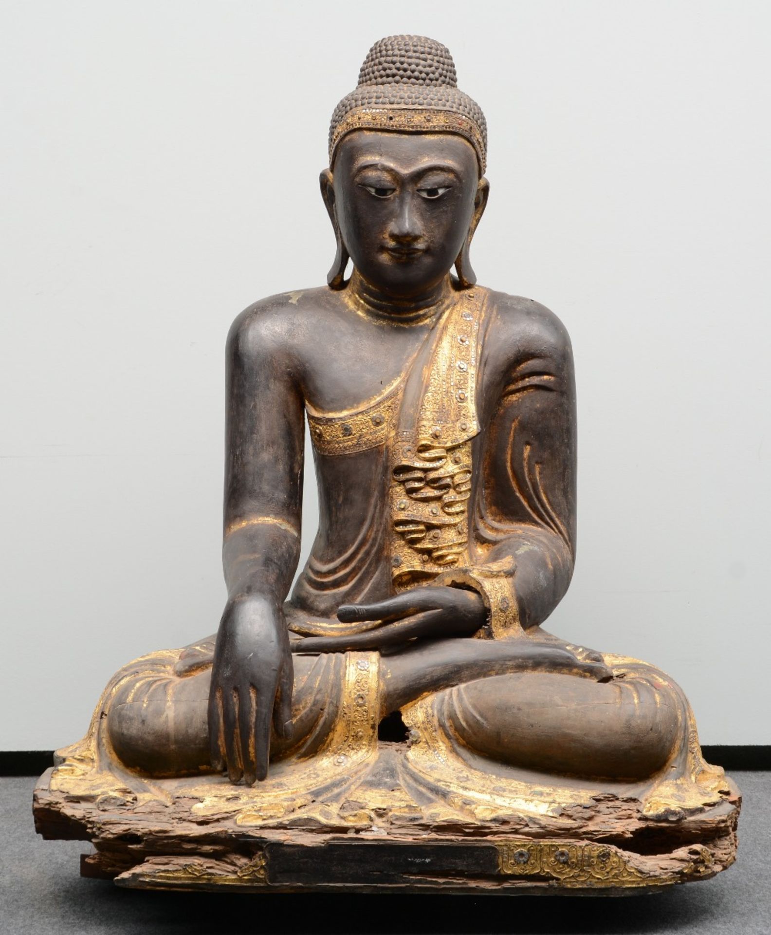 A rare Oriental gilt and polychrome decorated wooden Buddha, inlaid with rock crystal and other